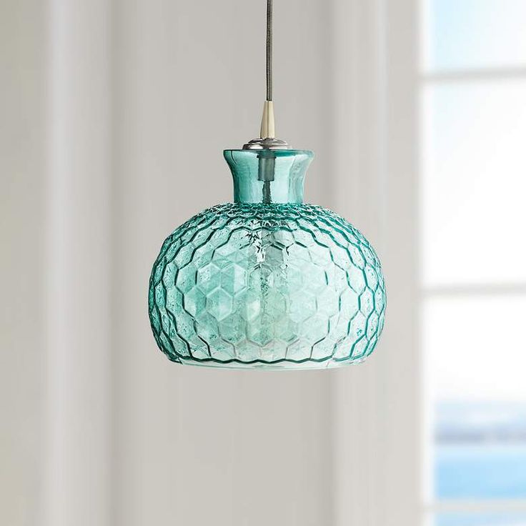 a blue glass light fixture hanging from a ceiling in a room with white walls and windows