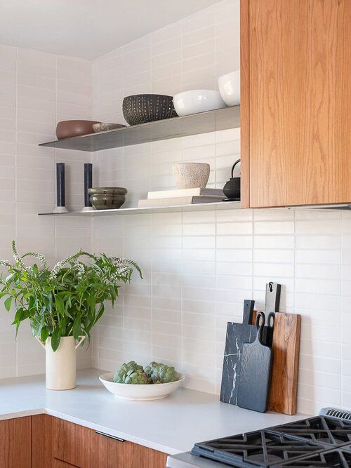 a kitchen with wooden cabinets and white counter tops, including a potted plant on the stove