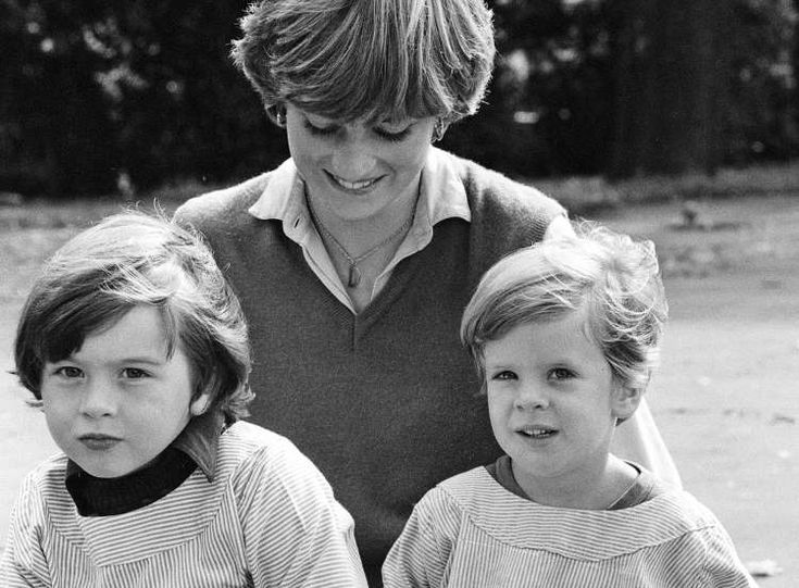 a woman and two children are sitting on the ground