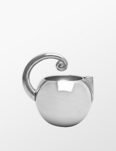 a silver vase with a curved handle on the top and bottom, sitting in front of a white background