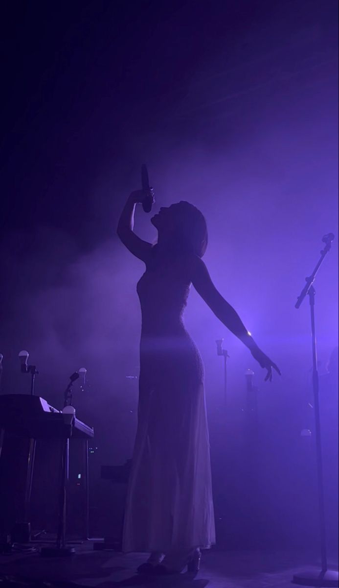 a woman standing in front of microphones on stage