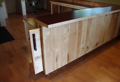 a kitchen island made out of plywood and steel with a sliding door on one side