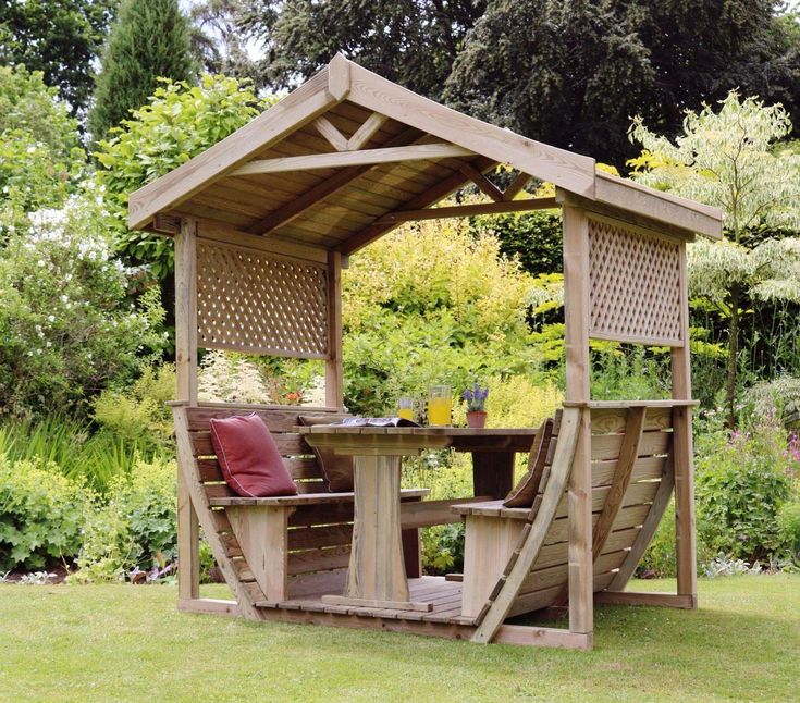 a wooden gazebo sitting on top of a lush green field