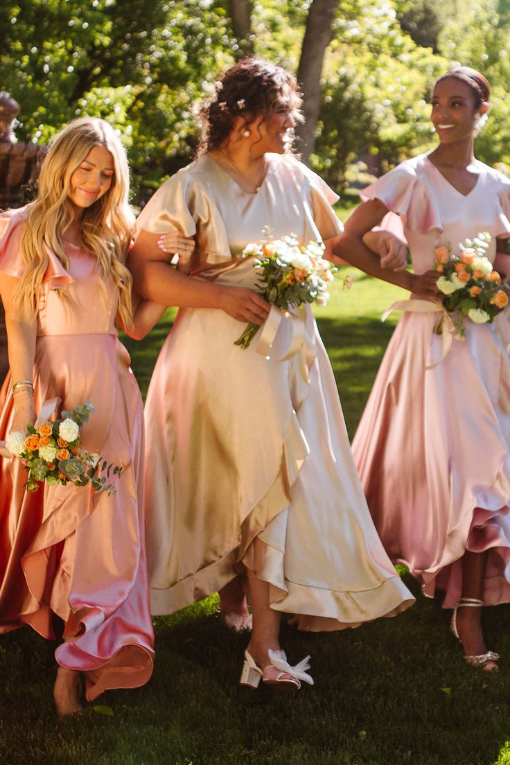 the bridesmaids are all dressed in pastel pinks and peachs for their wedding