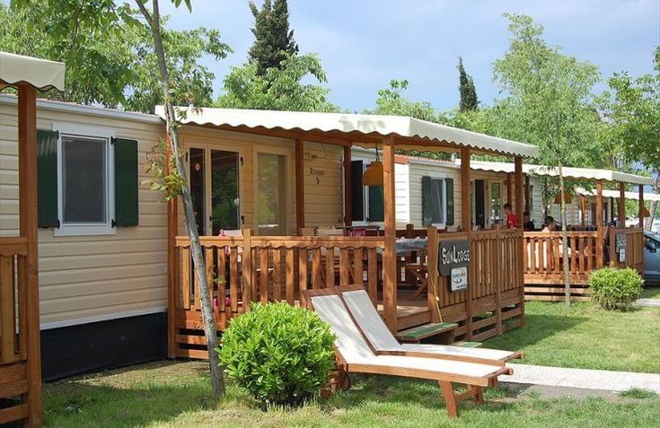 several mobile homes are lined up on the grass with lawn chairs and ...