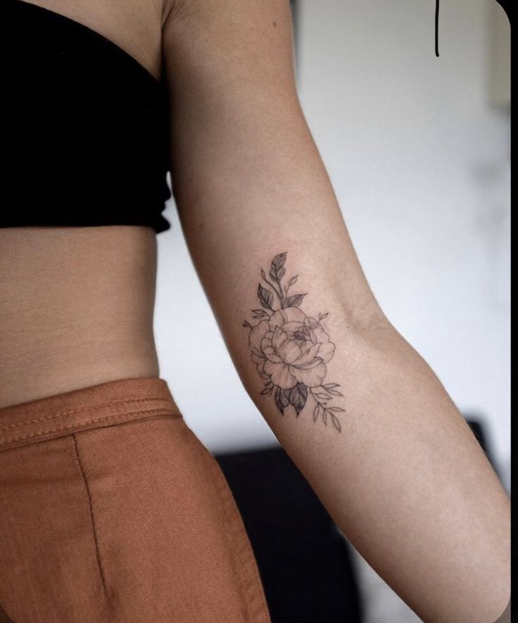 a woman's arm with a flower tattoo on the left side of her body