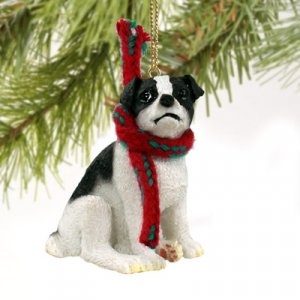 a dog ornament hanging from a christmas tree with a red scarf around it's neck