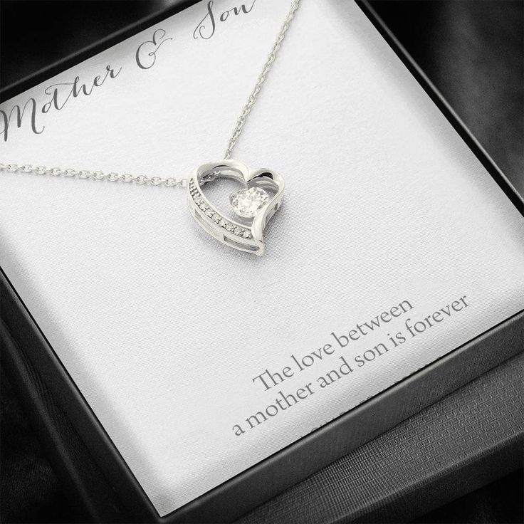 Give a loving gift that will make her heart melt! This dazzling Forever Love Necklace features a polished heart pendant surrounding a flawless 6.5mm cubic zirconia, embellished with smaller crystals adding extra sparkle and shine. The pendant is crafted in your choice of 14K white gold finish or 18K yellow gold finish, and dangles from an adjustable cable chain secured with a lobster clasp.Product Details:• 14K white gold finish or 18K yellow gold finish• Adjustable cable chain 18" - 22"• 6.5mm Son Necklace, Knot Stud Earrings, Mother And Son, Knot Studs, Tarnished Jewelry, Loving Gifts, Mothers Necklace, Mom Jewelry, Son Gift