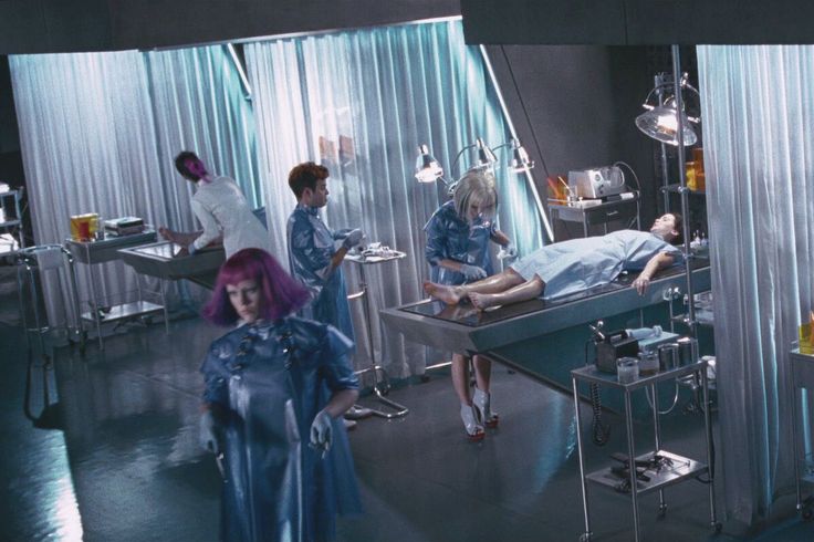 a group of people standing around a hospital bed