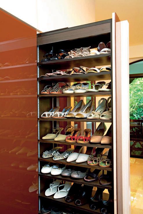 a large shoe rack with many pairs of shoes on it's shelves in a room