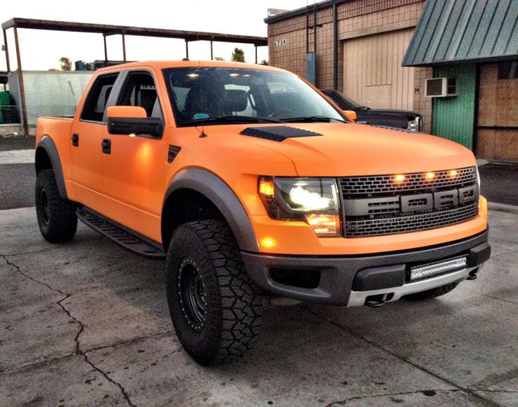 an orange truck parked in front of a building