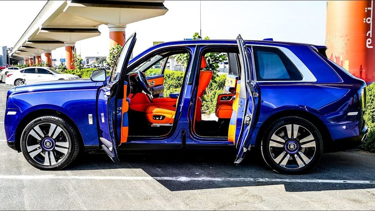 a blue car with its door open sitting in a parking lot