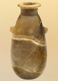 an old vase is hanging from the ceiling in front of a light colored wall behind it