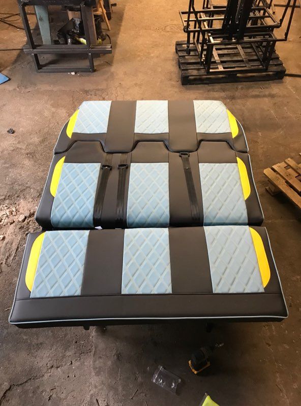 two black and yellow benches sitting on top of each other in a room filled with pallets