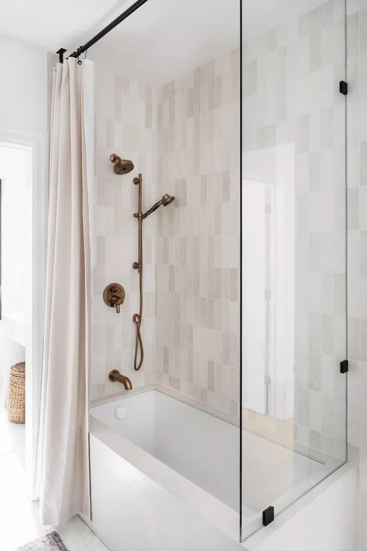 a bathroom with a tub, shower head and curtain