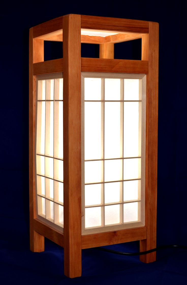 a light that is sitting on top of a wooden stand with an open window in the middle