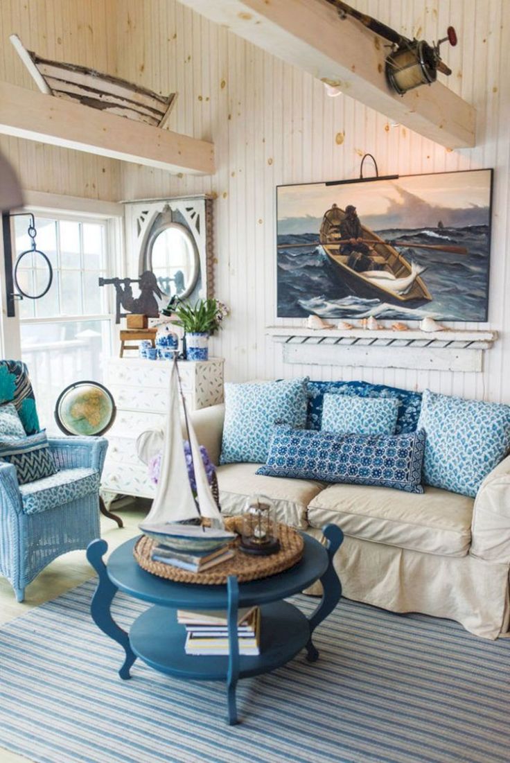 a living room filled with furniture and a sailboat painting on the wall above it