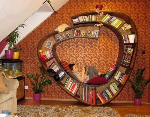 a woman laying on top of a book shelf in a living room next to a couch