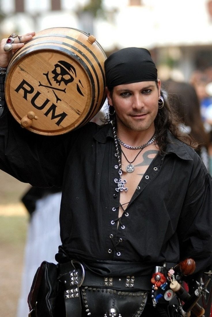 a man dressed in pirate clothing holding a wooden barrel with the word rum on it