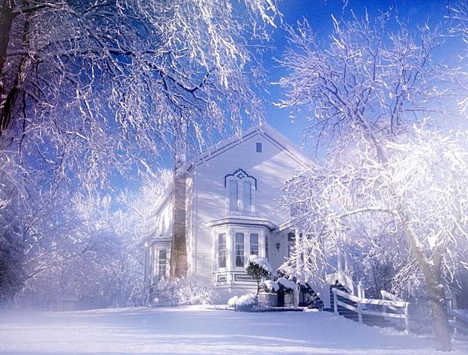 a white house surrounded by snow covered trees