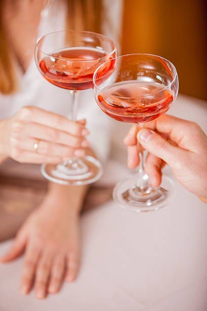 two people holding wine glasses in their hands