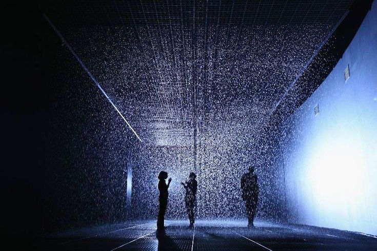 two people standing in the rain at night