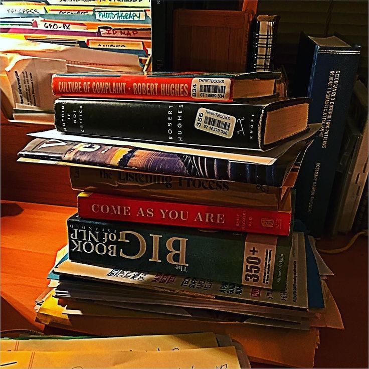 a stack of books sitting on top of a wooden table