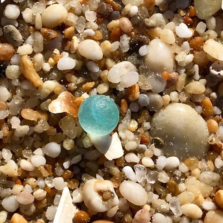 a blue object sitting on top of a pile of rocks and gravel next to water