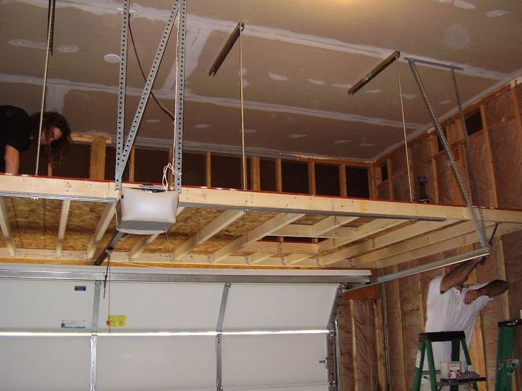 two men working on the ceiling in a garage