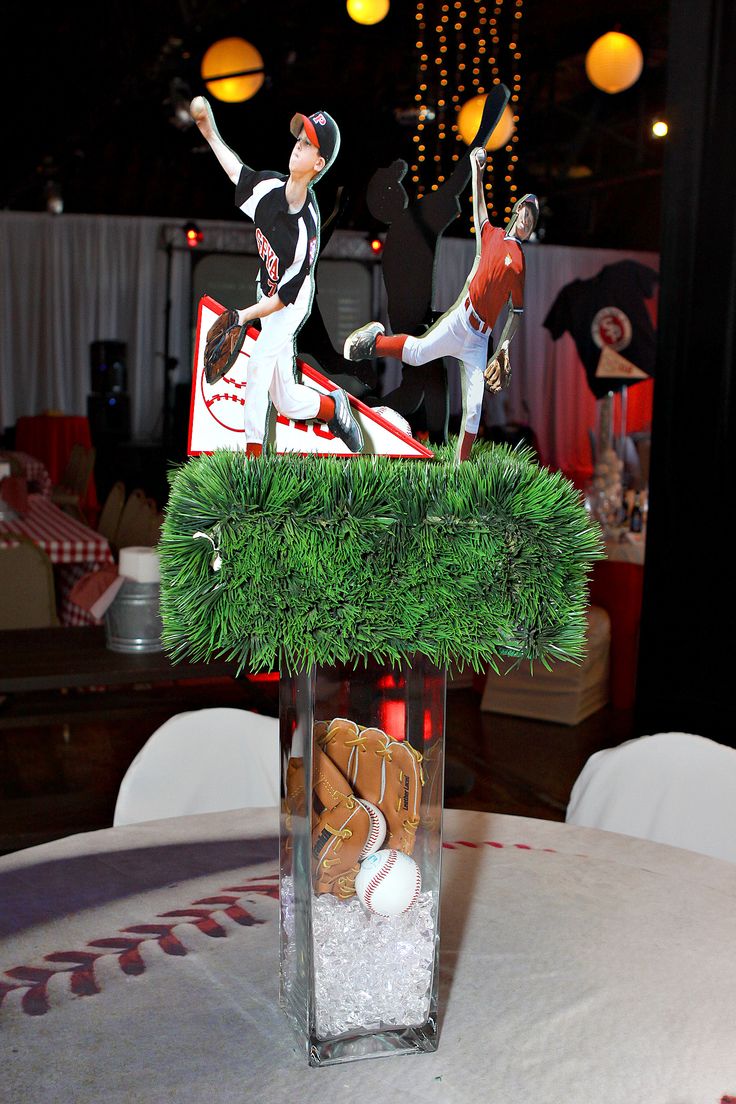 two figurines on top of a table with baseballs and mitts in it