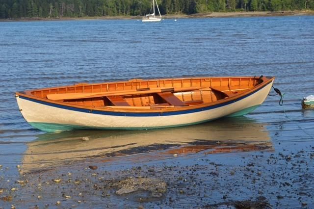 a small boat sitting on top of a body of water next to a shore line