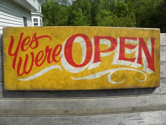 a yellow sign that says yes we're open