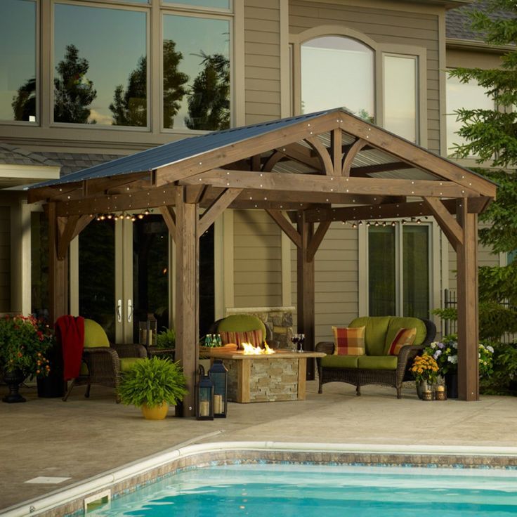 an outdoor patio with a pool and gazebo