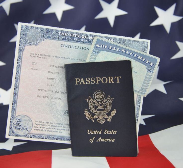 a passport sitting on top of an american flag next to a visa card and us dollar bill