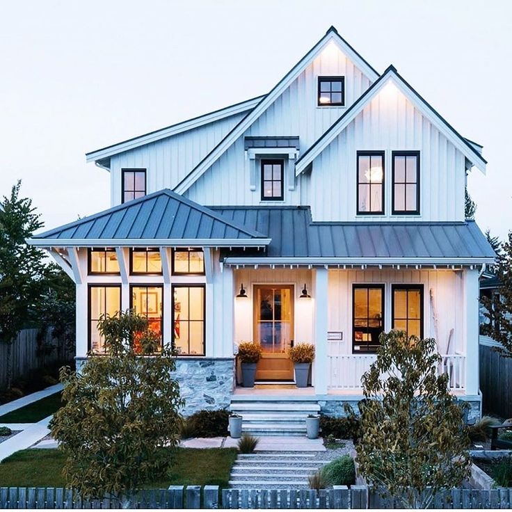 a white house with lots of windows and steps leading up to the front door area