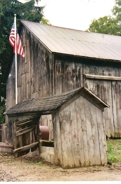 an old barn with the american flag on top