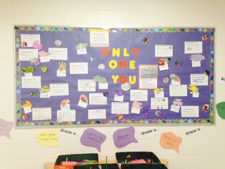 a bulletin board with some writing on it and two bins full of papers in front of it