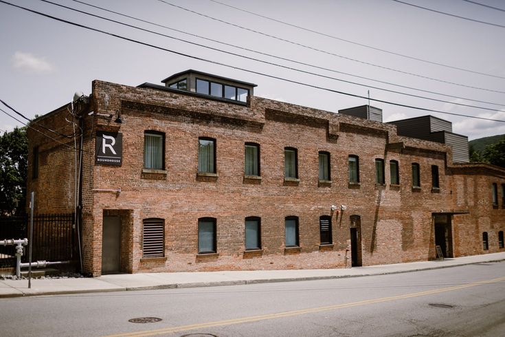 an old brick building with windows and shutters on the side of the street in front of power lines