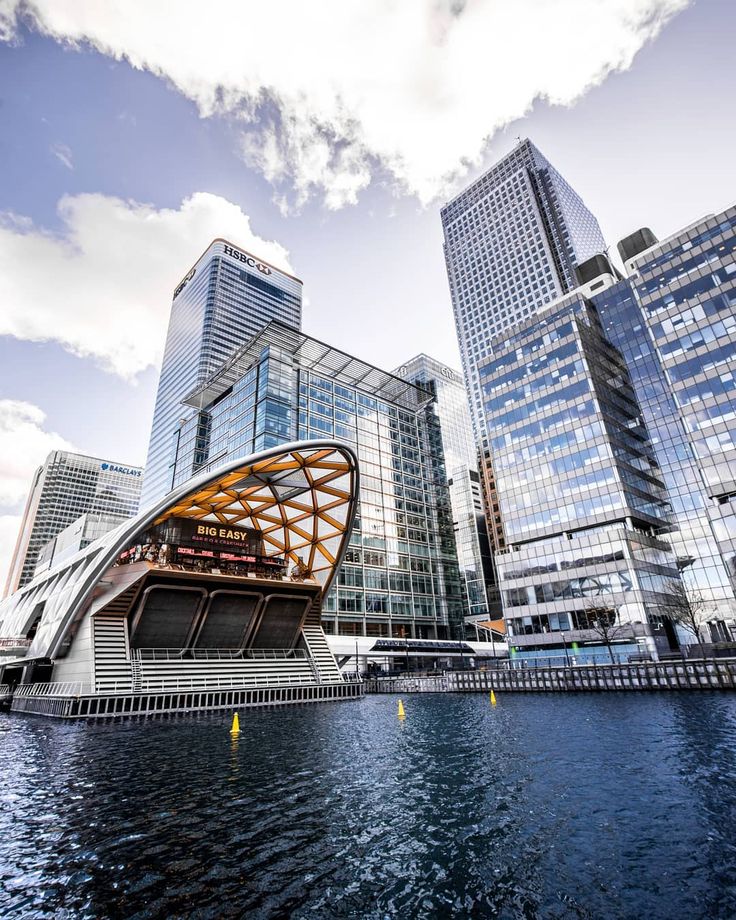 a boat floating on top of a body of water next to tall buildings in the city