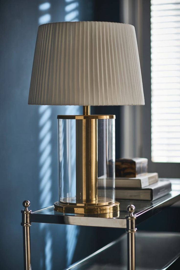 a lamp that is sitting on top of a table next to a bookshelf