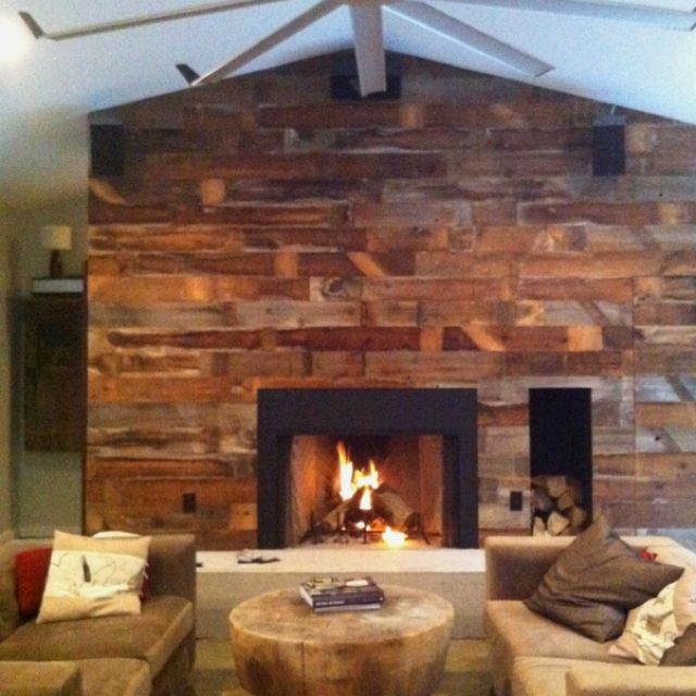 a living room with two couches and a fire place in the center, next to a fireplace