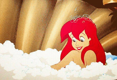 the little mermaid is sitting in the bathtub