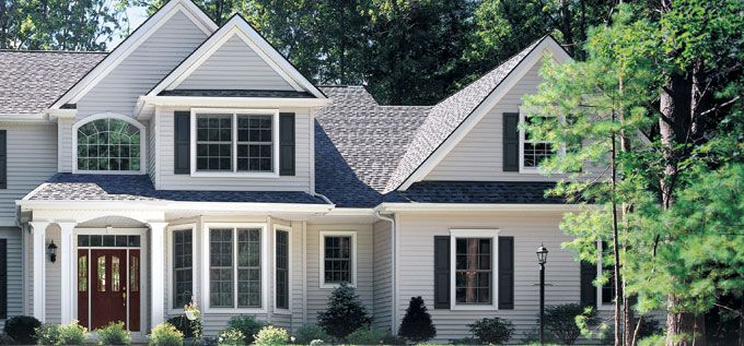 a white house with black shutters and red door