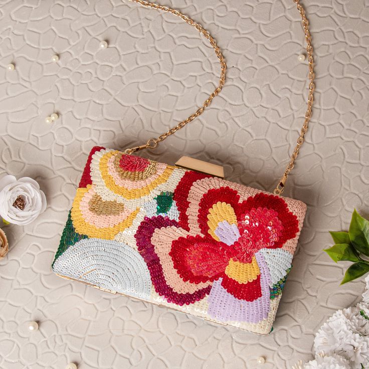 a purse sitting on top of a table next to flowers