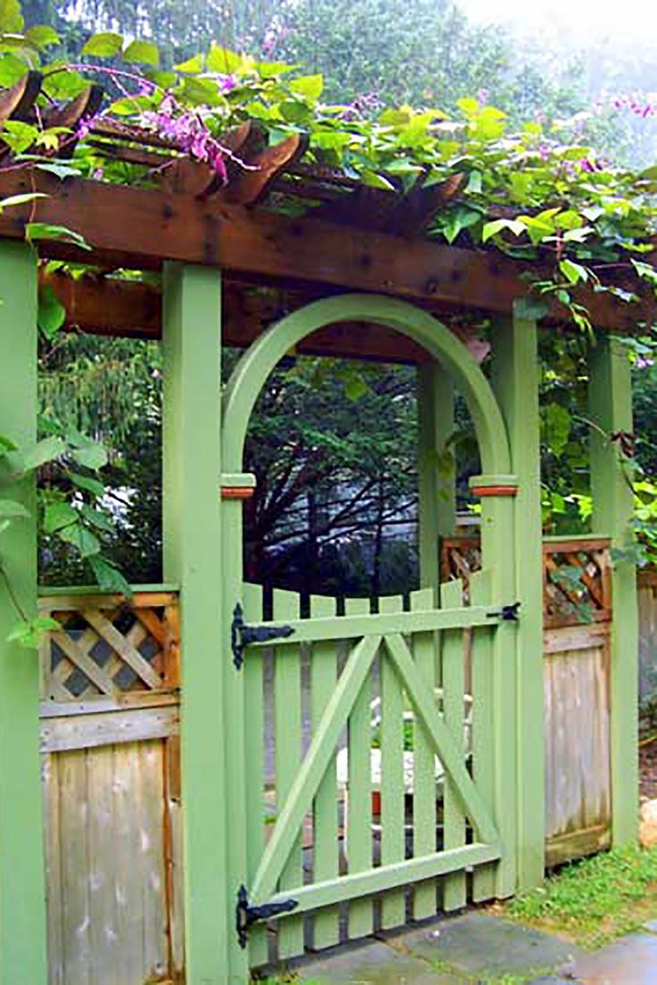 a green garden gate surrounded by greenery