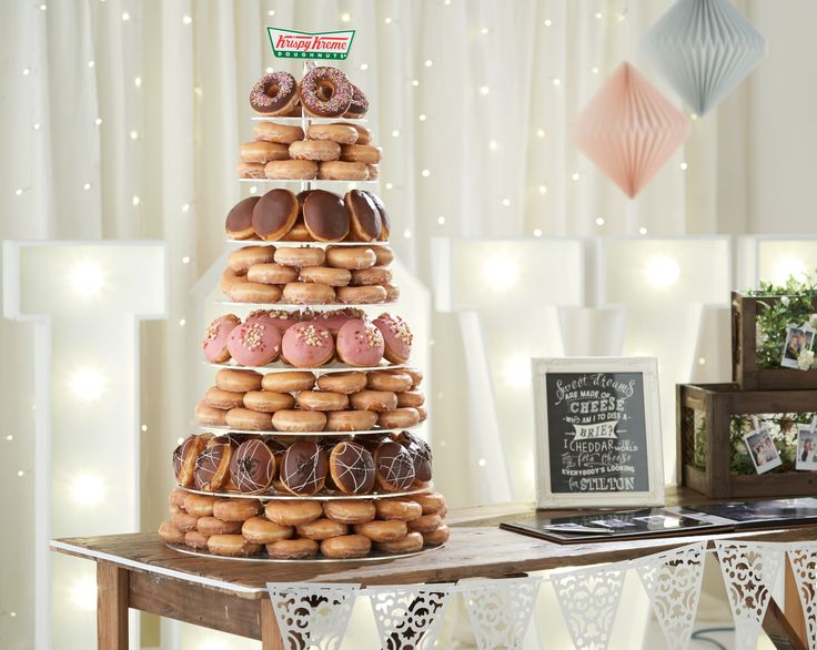 a tower of doughnuts sits on a table in front of other items and decorations