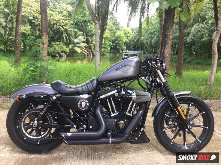 a black motorcycle parked in front of some trees