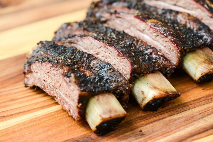 sliced up meat sitting on top of a wooden cutting board