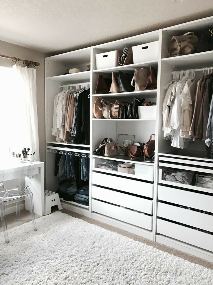 an image of a closet with clothes and other items on the shelves in front of it