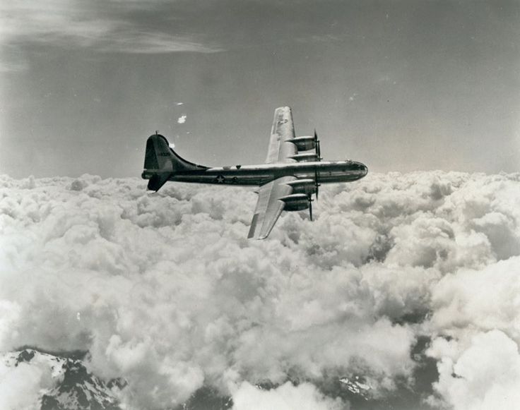 an airplane flying above the clouds in black and white